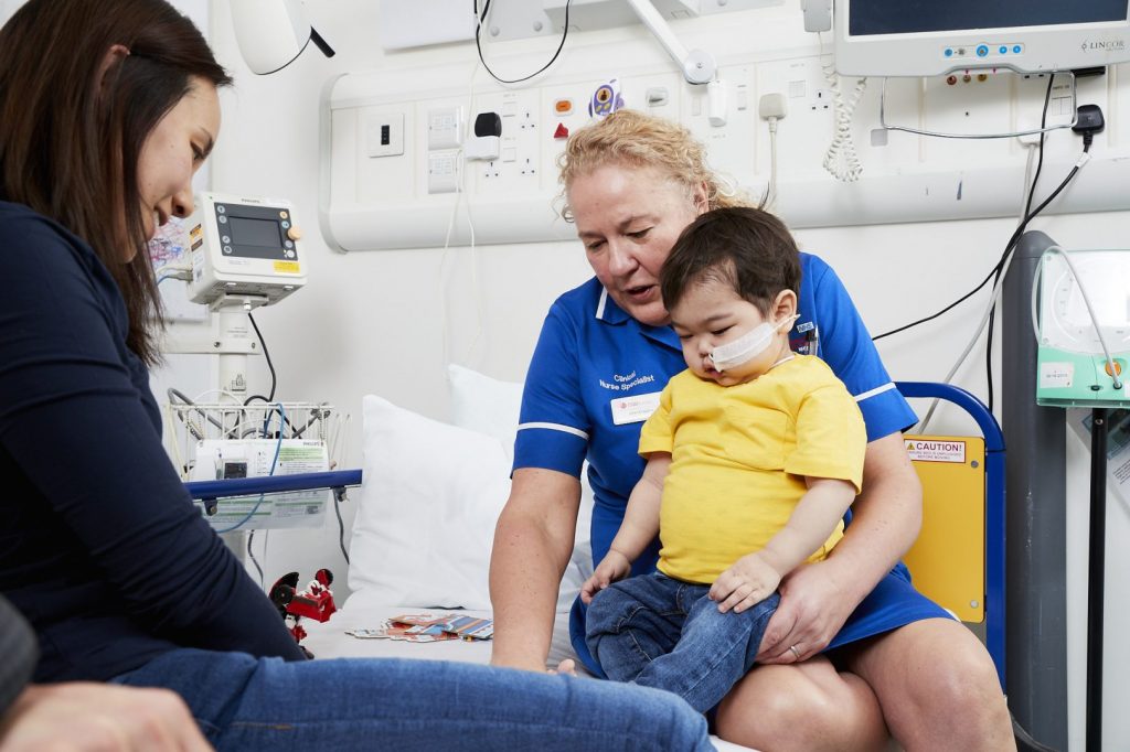 nurse with boy on bed in hospital