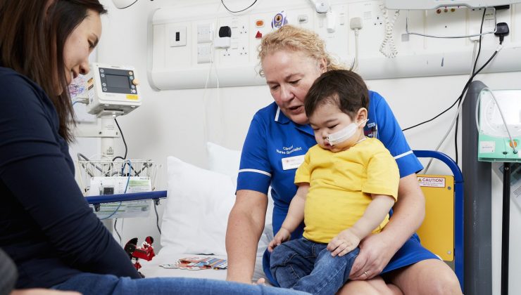 nurse with boy on bed in hospital